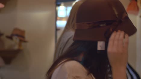 Two-young-women-trying-on-hats-in-a-store