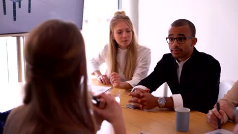 African-american-businessman-and-business-team-high-five-in-meeting-room