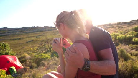 Camping-Hiker-drinking-coffee-in-nature-next-to-tent