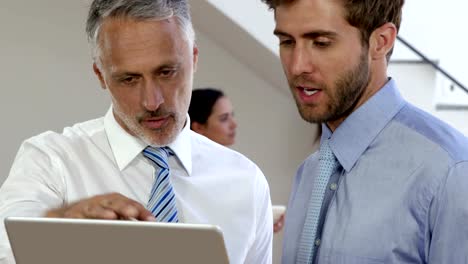 Businessman-talking-in-front-of-the-camera-while-businesswoman