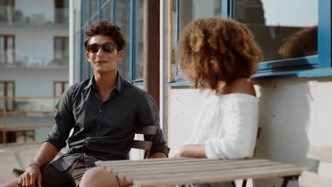 Young-couple-sitting-and-chatting-at-cafe