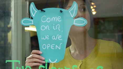 Female-Owner-Of-Coffee-Shop-Turning-Open-Sign-Shot-On-R3D