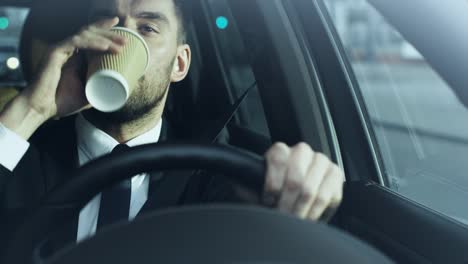Businessman-Driving-a-Car-in-the-Morning,-Drinking-Coffee.