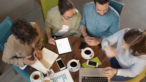 Pequeño-equipo-creativo-de-la-gente-joven-activa-con-reunión-y-discusión-en-la-cafetería.