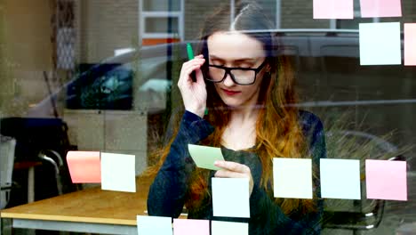 Business-executive-reading-at-sticky-note-while-having-cup-of-coffee