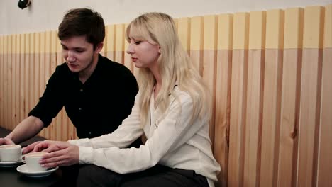 Young,-beautiful-couple-having-a-date-in-cafe,-talking-and-drinking-coffee