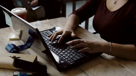 Close-up-view-of-young-african-designer-woman-working-at-laptop.-Businesswoman-uses-computer,-typing-at-keyboard