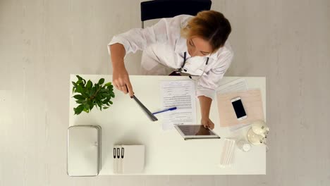 Female-doctor-uses-digital-tablet-to-talk-with-patient-by-scype-in-medical-office