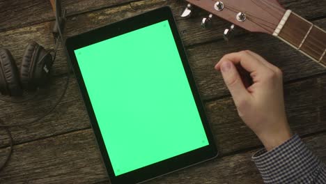 Musician-Using-Tablet-PC-with-Green-Screen-in-Portrait-Mode.-Top-view.-Causal-Lifestyle