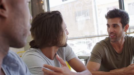 Three-Male-Friends-Meeting-In-Coffee-Shop-Shot-In-Slow-Motion