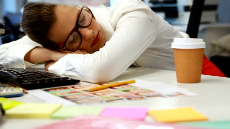 Female-graphic-designer-sleeping-at-desk