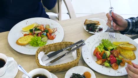 Healthy-vegetable-salads-young-family-eating-at-restaurant