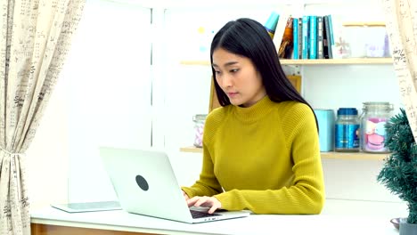 Young-lady-working-with-laptop-computer-in-livingroom