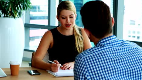 Executives-interacting-with-each-other-at-desk