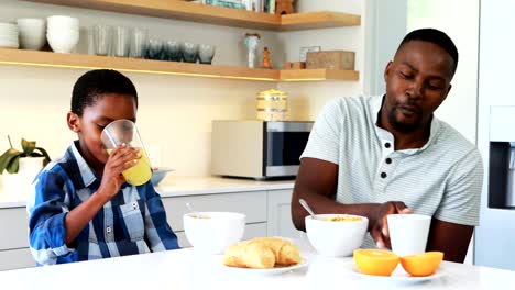 Father-and-son-having-breakfast-in-kitchen