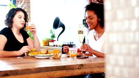 Lesbian-couple-interacting-with-each-other-while-having-breakfast