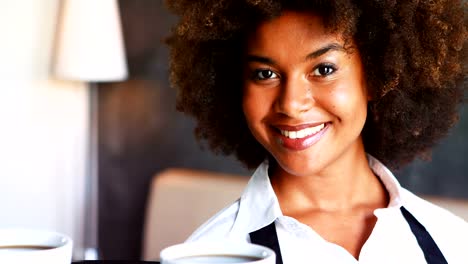 Portrait-of-smiling-waitress-holding-tray-of-coffee-cups