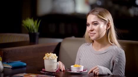 Cheerful-woman-having-delicious-snack-in-modern-cafe-posing-happily