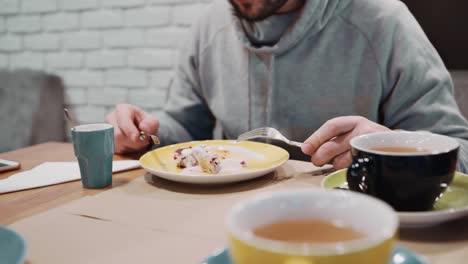 Unrecognizable-girl-eating-dessert-strudel-at-the-restaurant-using-fork-and-knife