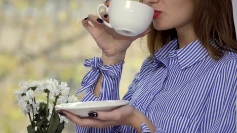 Stilvolle-Frau-mit-roten-Lippen-trinkt-Kaffee