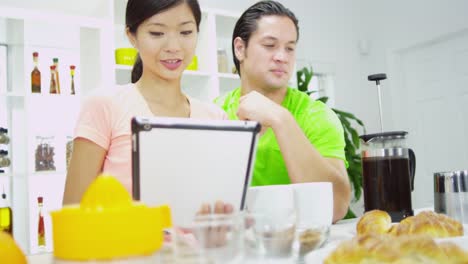 Young-Ethnic-couple-using-wireless-tablet-at-breakfast