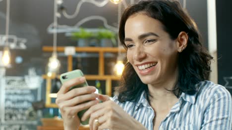 Schöne-Frau-nutzt-Smartphone-beim-Sitzen-im-Cafe.-Hintergrund-dieses-stilvolle-Café.