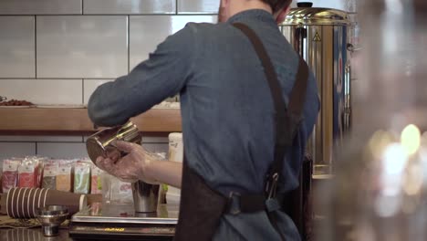 Jungen-Barista-Kerl-gießt-eine-Milch-Mischung-in-einen-Shaker,-bereiten-Sie-einen-Protein-cocktail