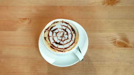 Weibliche-Hände-setzen-Kaffeetasse-auf-dem-Tisch,-Ansicht-von-oben