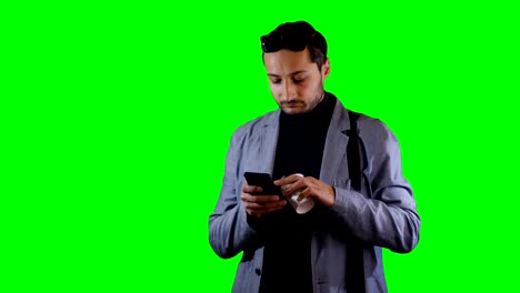 Man-in-suit-a-use-mobile-and-hold-coffee-cup.-Green-screen,-footage.