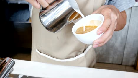 Close-up-hand-of-barista-making-latte-art-at-cafe.