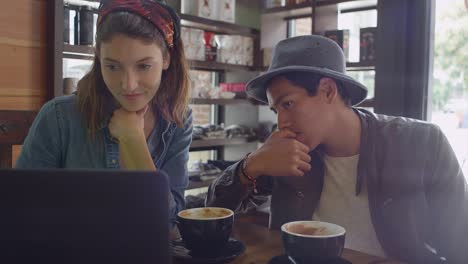 A-young-couple-looking-a-laptop-in-a-coffee-shop