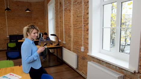 Hermosa-mujer-bebiendo-café-smartphone-en-la-oficina-moderna-loft