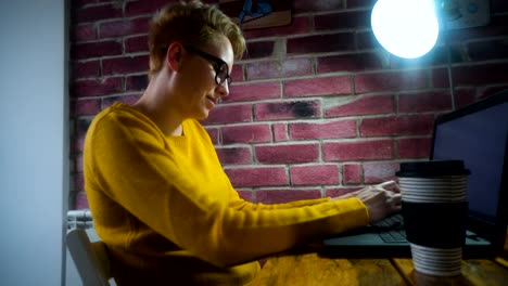 Attractive-young-woman-working-at-the-desk-with-a-laptop-in-home-office.