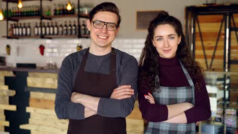 Porträt-von-zwei-Kaffee-Haus-Besitzer-attraktive-junge-Menschen-stehen-im-Kaffee-Shop,-lächelnd-und-Blick-in-die-Kamera.-Erfolgreiche-Inbetriebnahme-und-schöne-Menschen-Konzept.