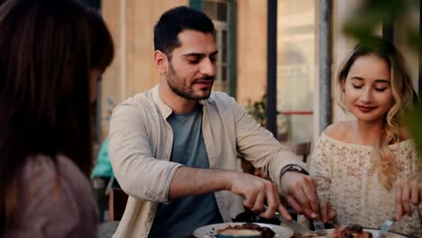 Young-couple-having-fun-with-friends-at-traditional-coffee-shop