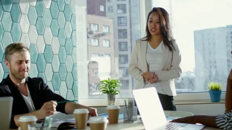 Female-Asian-Manager-Talking-to-Colleagues-at-Meeting