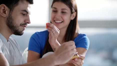 Joven-pareja-comer-el-desayuno-en-casa-el-domingo