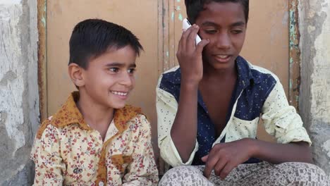 Indian-kids-talking-on-mobile-cell-phone,-excited-and-happy,-talking