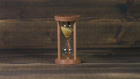 Sandglass-clock-on-wooden-table