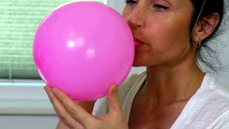 Woman-blows-the-balloon-in-close-up