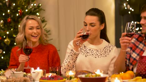 amigos-felices-bebiendo-vino-tinto-en-Navidad