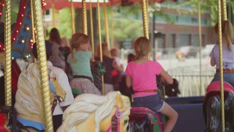 Tres-niñas-riding-en-un-carrusel