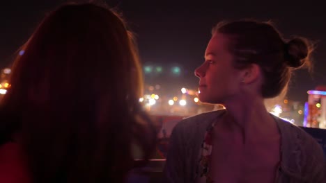 Two-friends-on-a-ferris-wheel-at-night