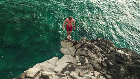 Aerial-view-cliff-jumping-into-ocean