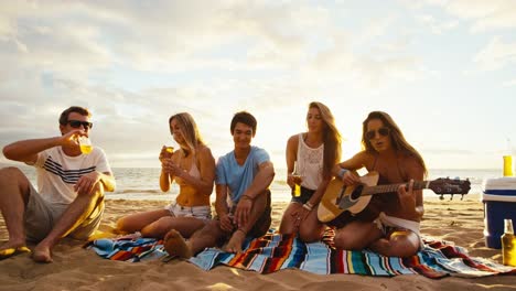 Freunde-am-Strand-bei-Sonnenuntergang-entspannen