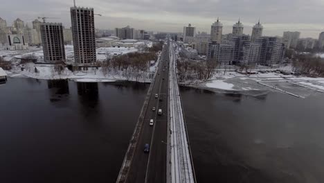 Stadtverkehr-auf-der-Brücke,-es-schneit