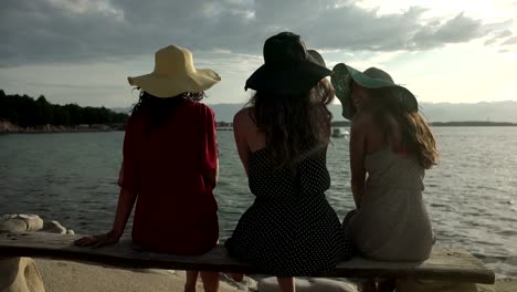 Girlfriends-at-beach-enjoying-sunrise-and-talking