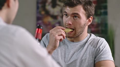 Man-Eating-Chips-and-Talking-with-Friend