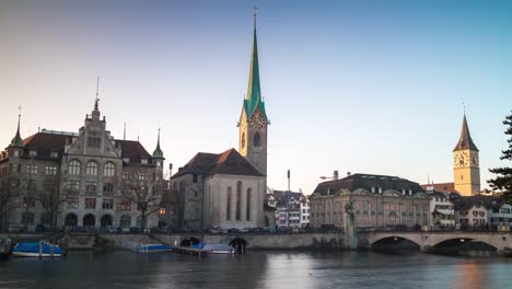 Suiza-al-atardecer-famoso-zurich-ciudad-señora-minster-Catedral-Torres-río-lado-panorama-4k-lapso-de-tiempo