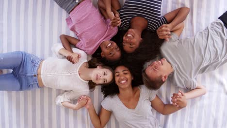 Vista-aérea-de-amigos-adolescentes-acostado-en-la-cama-juntos